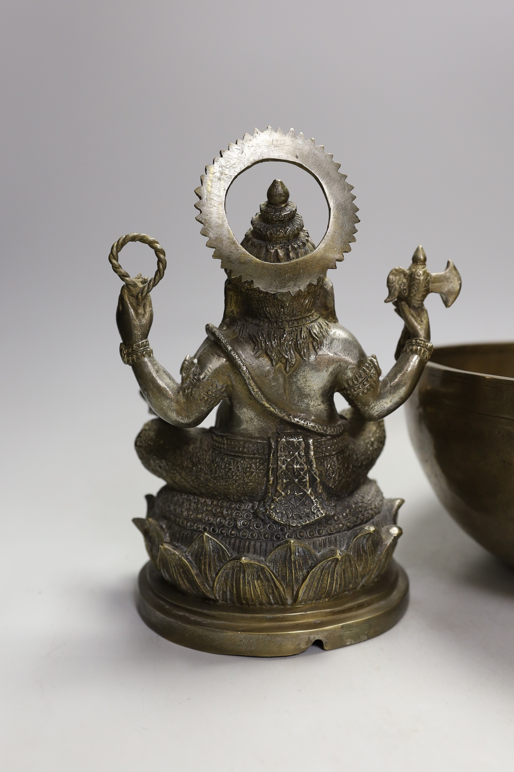 A plated figure of Ganesha and a Tibetan singing bowl with striker